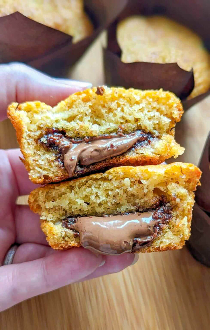 une main tenant un muffins Nutella banane moelleux.