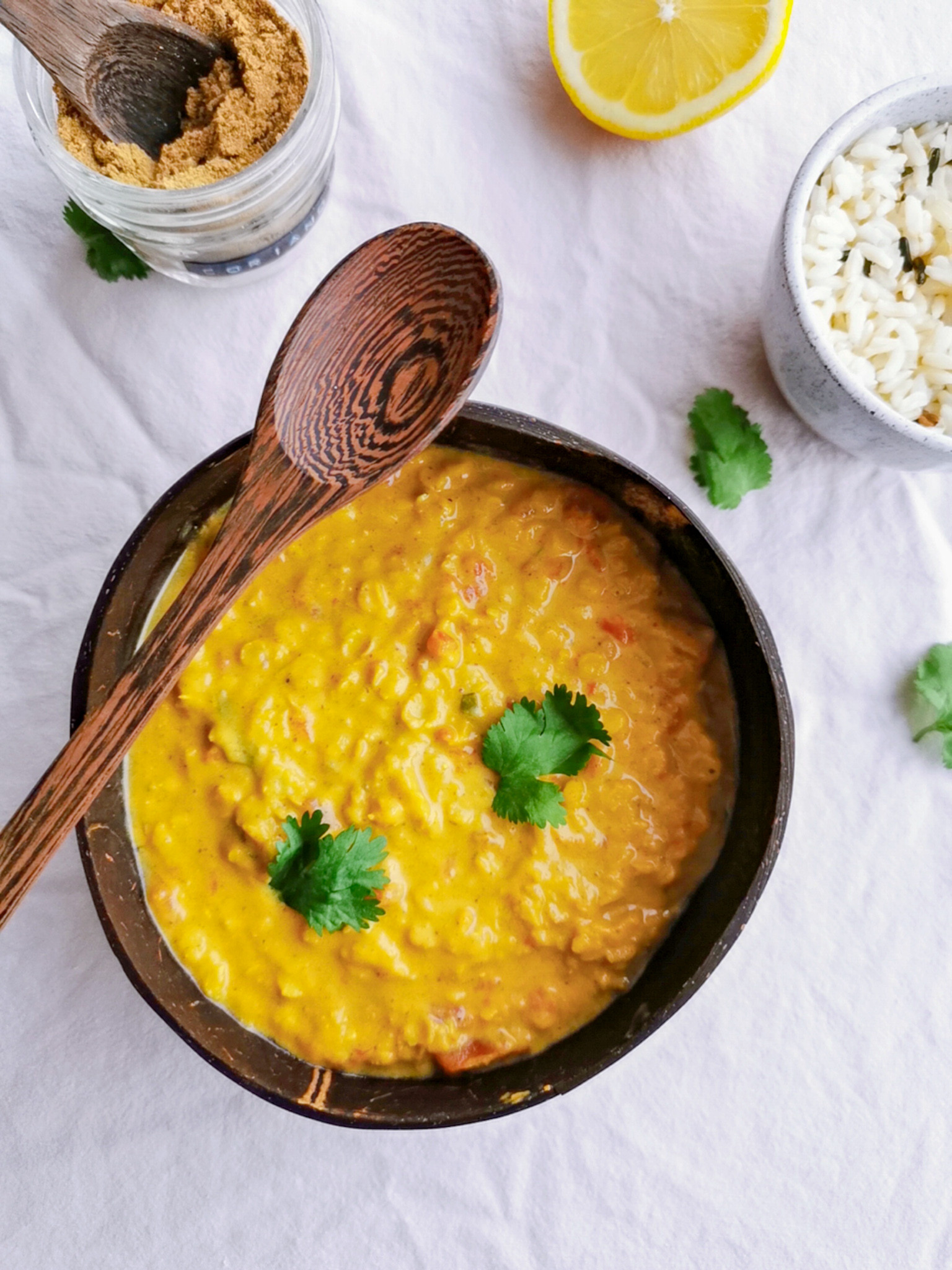 Un curry de lentilles rouges dans un bol de noix de coco.