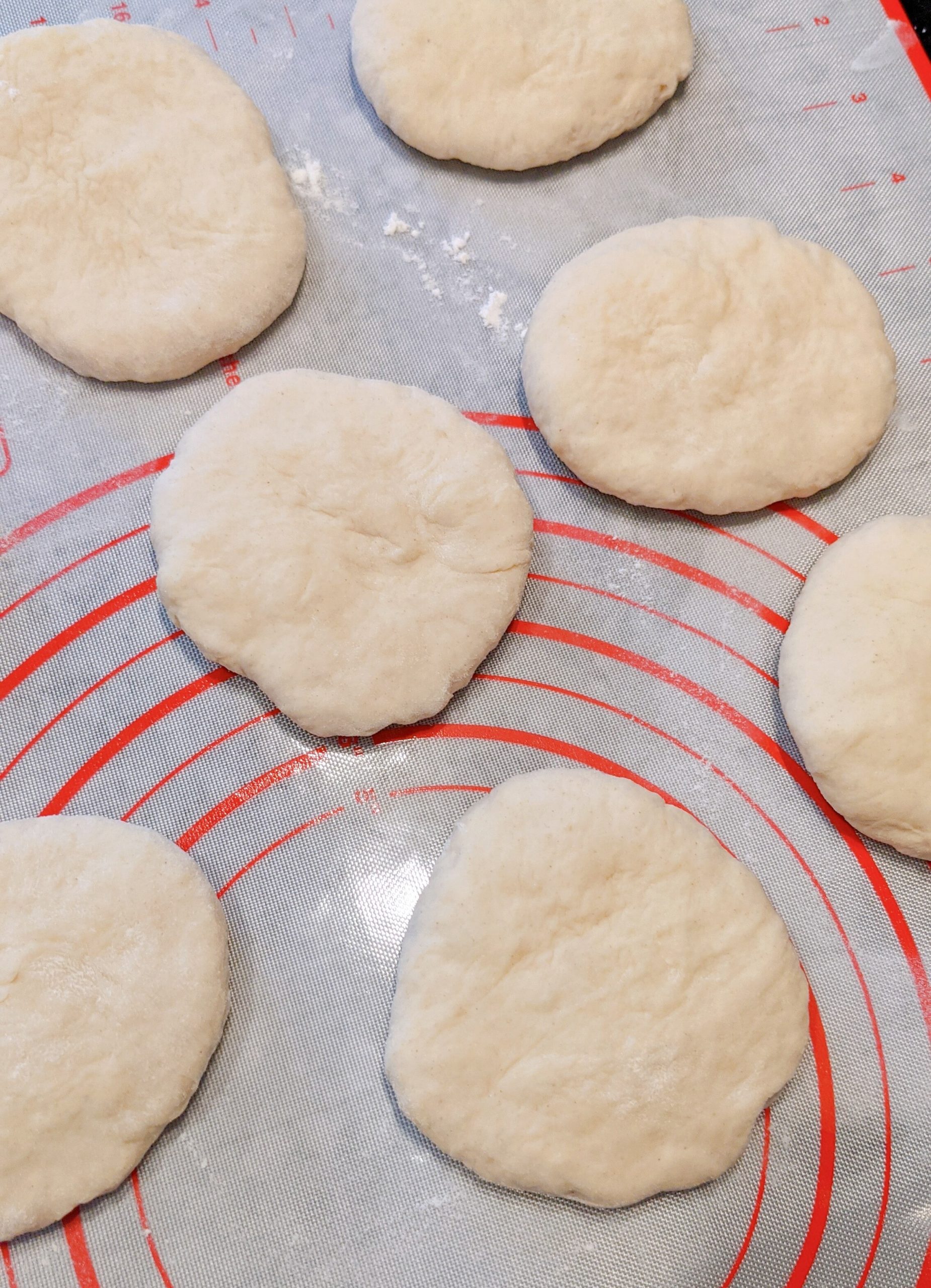 des petits pains ronds sur une plaque avant cuisson.