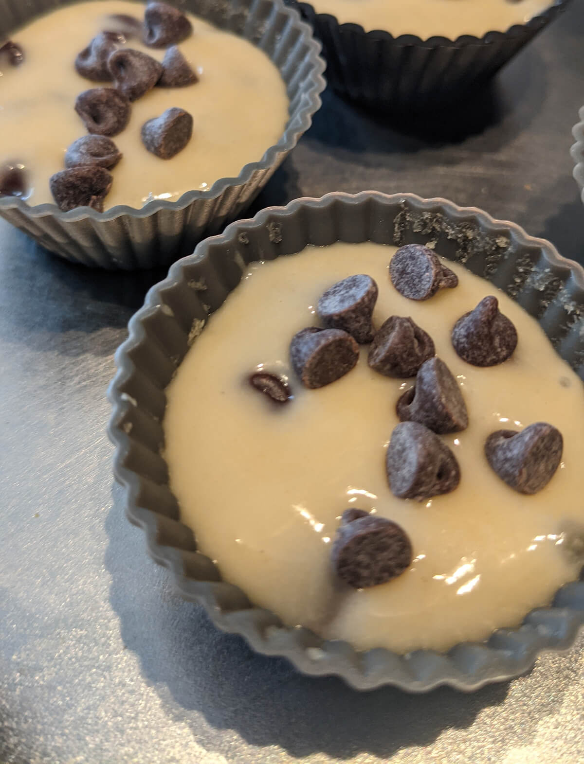 Pâte à muffins dans les mini-moules pour la cuisson des mini-muffins pépites de chocolat.