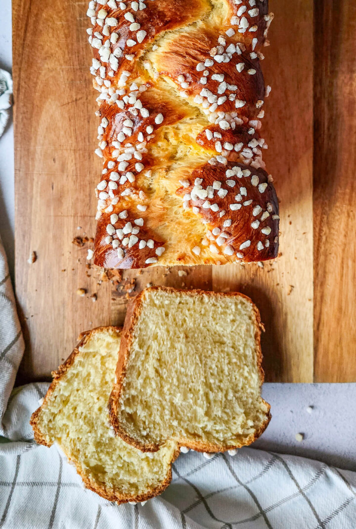 Des tranche de brioche tressée sur une planche en bois.