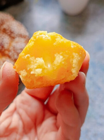 Une madeleine coeur fondant citron dans une main.