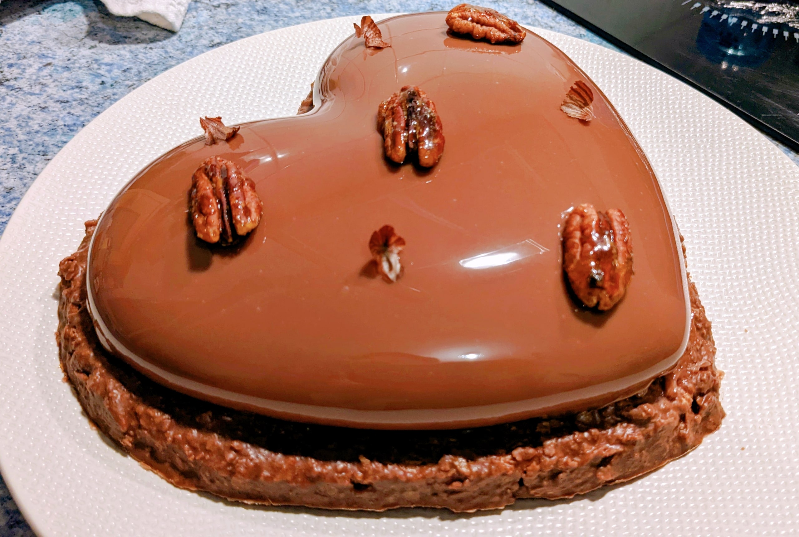 Un entremets au chocolat sur une assiette blanche.