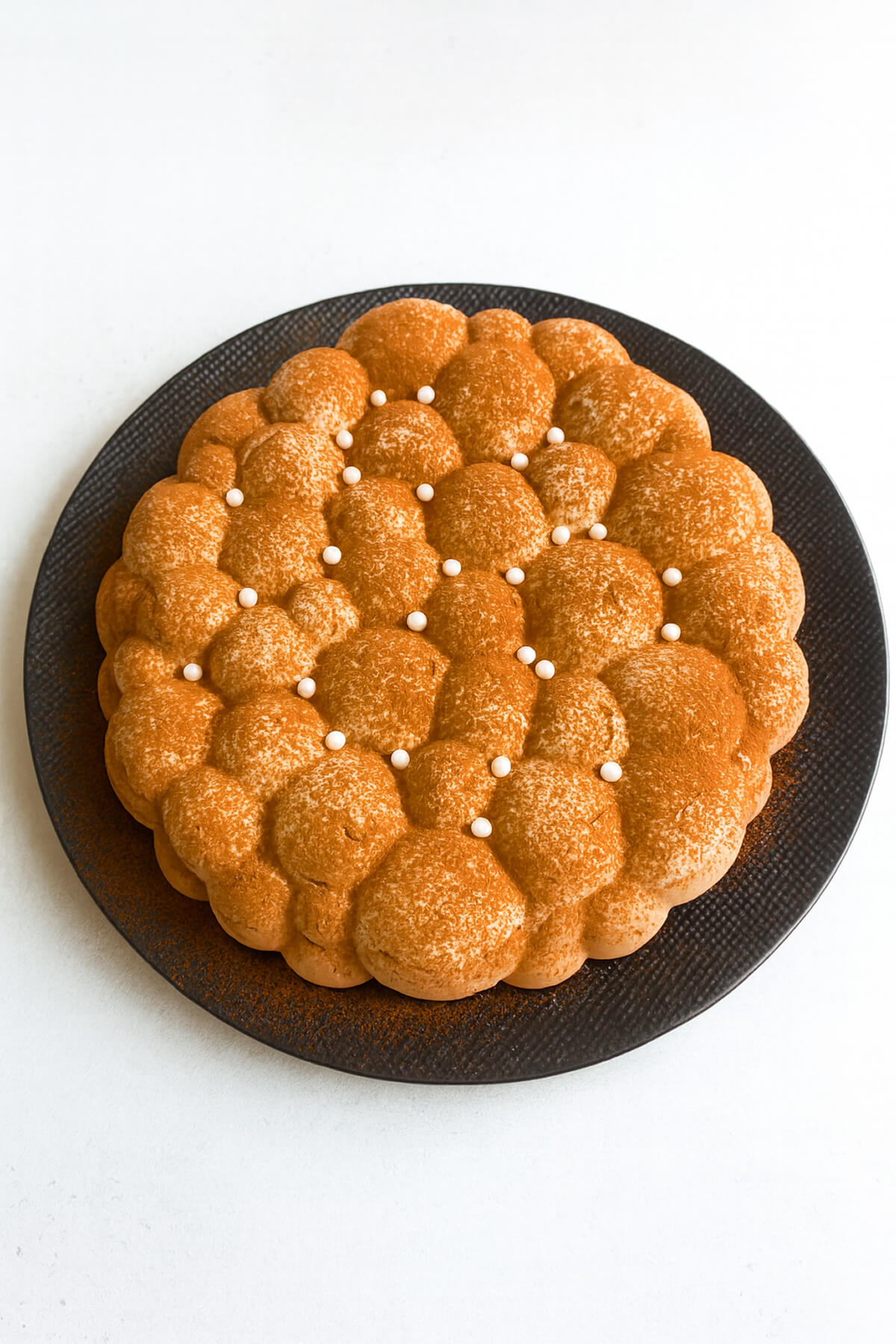 Un entremets aux trois chocolats très facile à réaliser, dans une assiette noire.