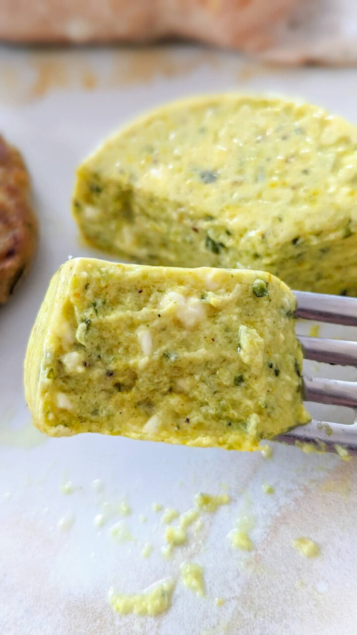 Une fourchette tenant un morceau de flan de courgettes à la sortie du four,, montrant une texture légère et fondante.