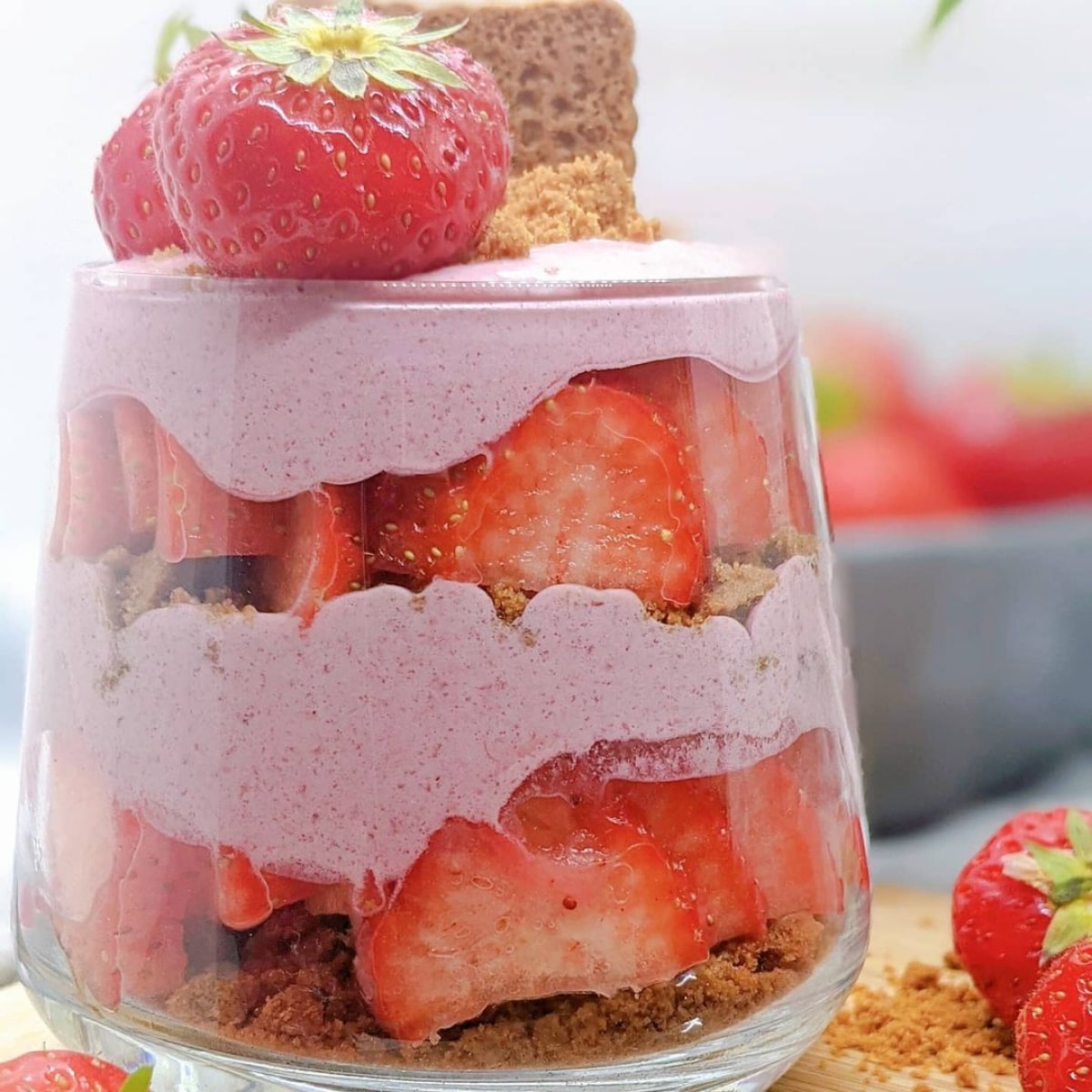 Un tiramisu fraise dans un verre avec des fraises sur le dessus.