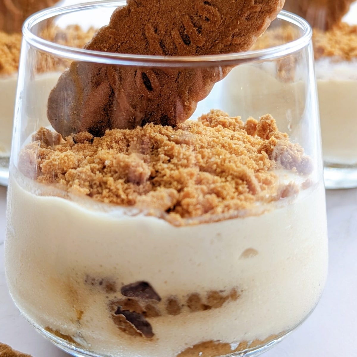 Un tiramisu spéculoos dans un petit verre, avec un biscuit spéculoos sur le dessus.