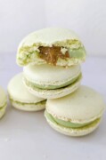 Quelques macarons empilés les uns sur les autres avec un macaron ouvert en deux.