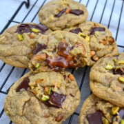 Des cookies choco pistache sur une plaque de refroidissement.