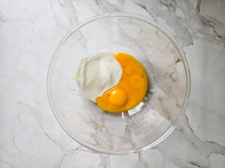 Des ingrédients dans un bol en verre sur un fond blanc marbré.