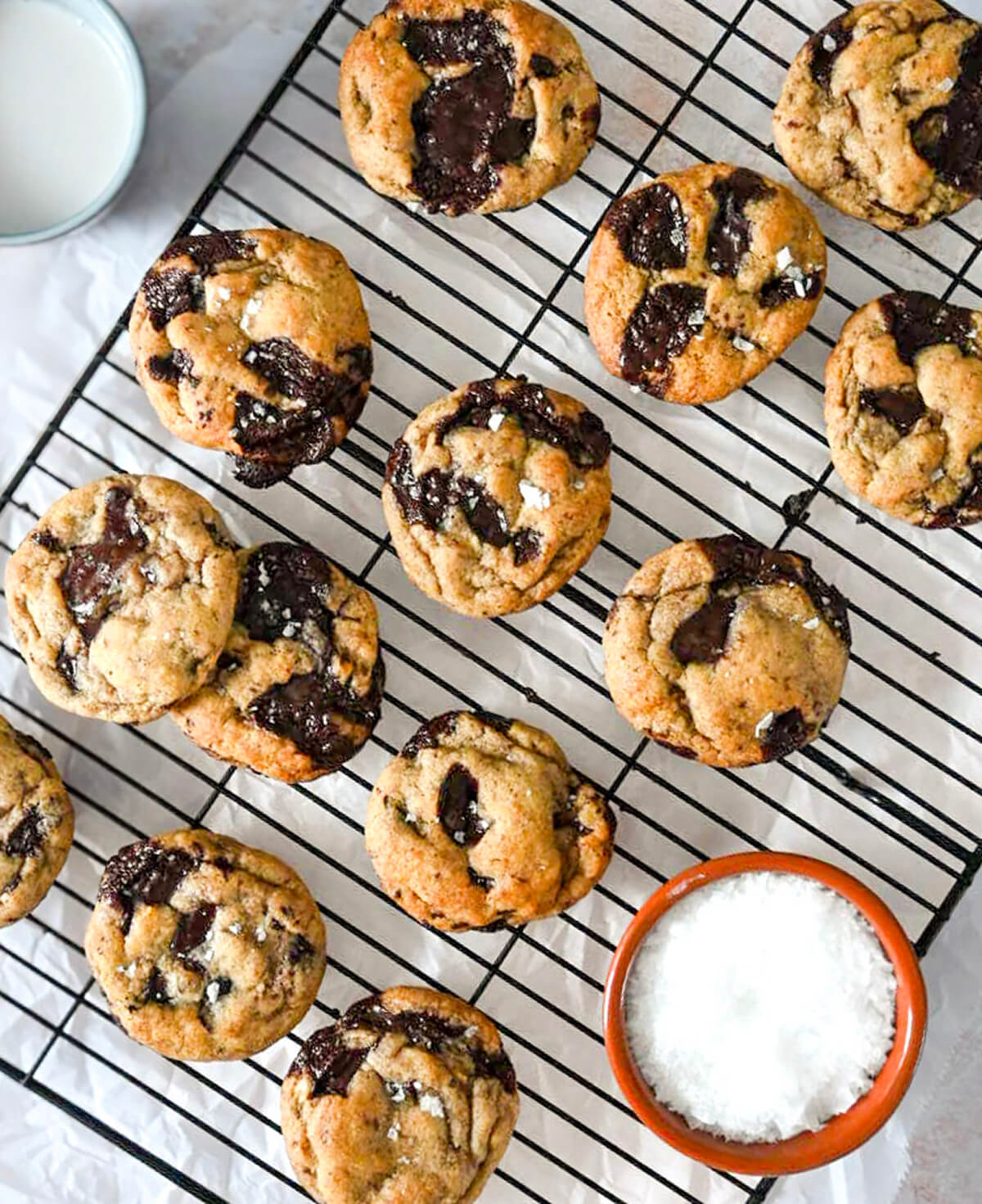 Des cookies banane chocolat sur une plaque de refroidissement noire, avec fleur de sel sur le coté.