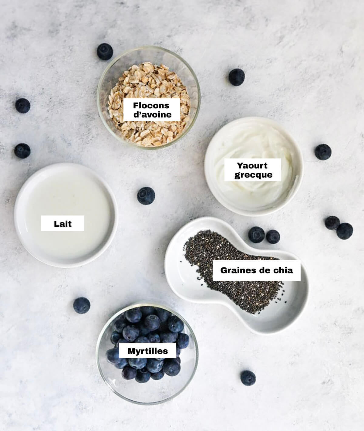 Des ingrédients pour une recette de porridge, sur un fond blanc gris.