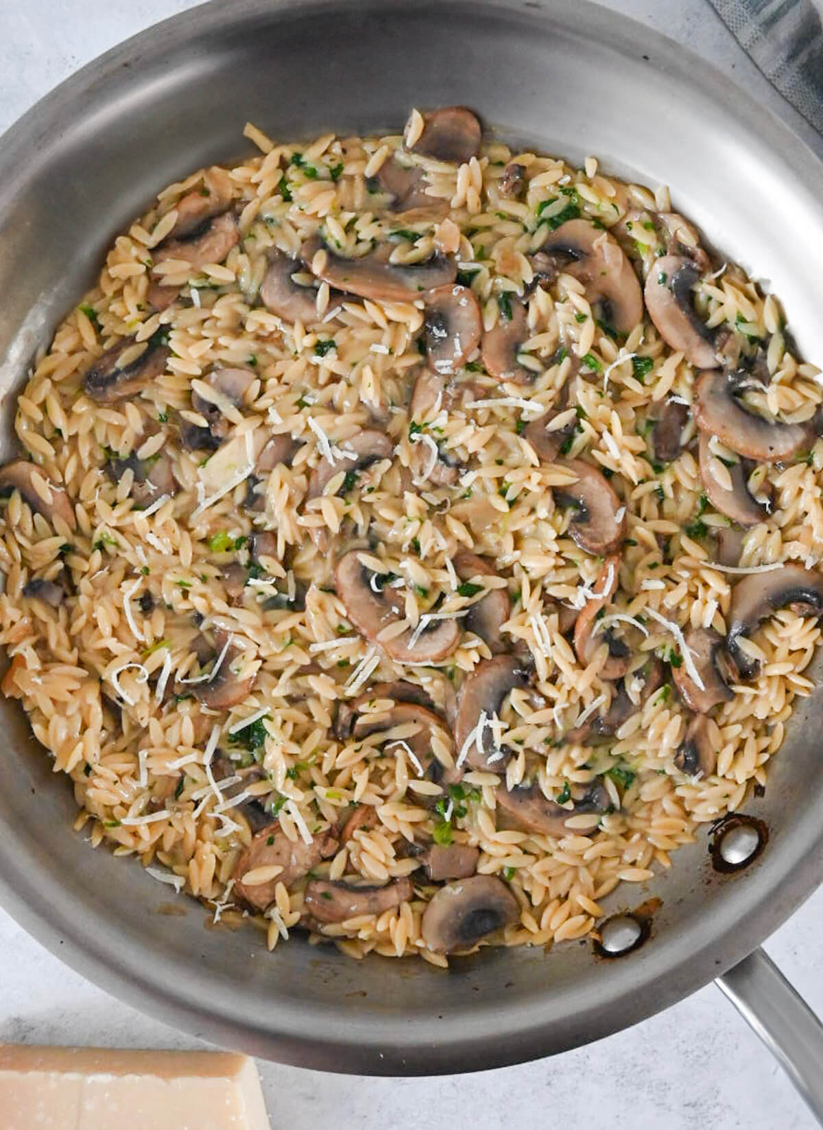 Des Pâtes Orzo Aux Champignons dans une poele en inox.