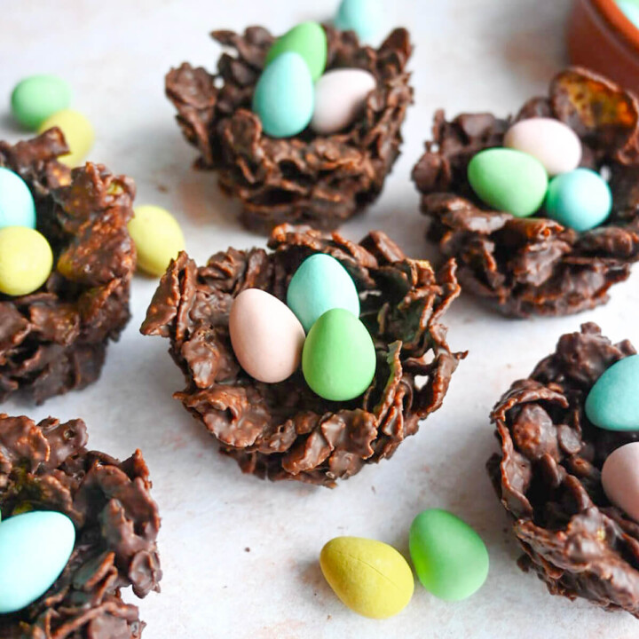 Des nids de Pâques express sur une surface rose clair.