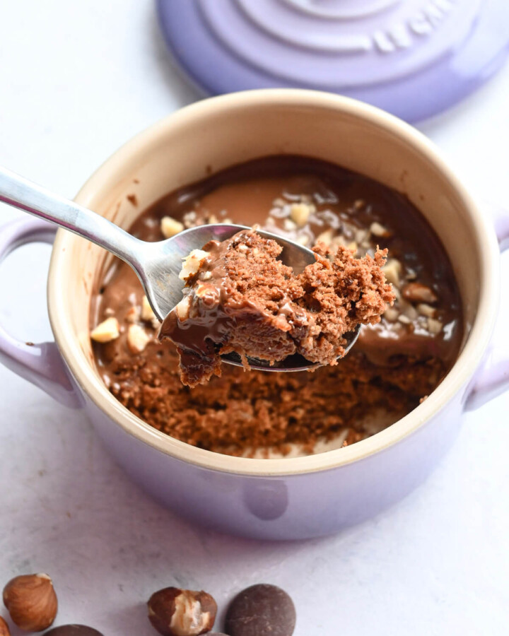 Une fourchette tenant un morceau de mug cake chocolat.