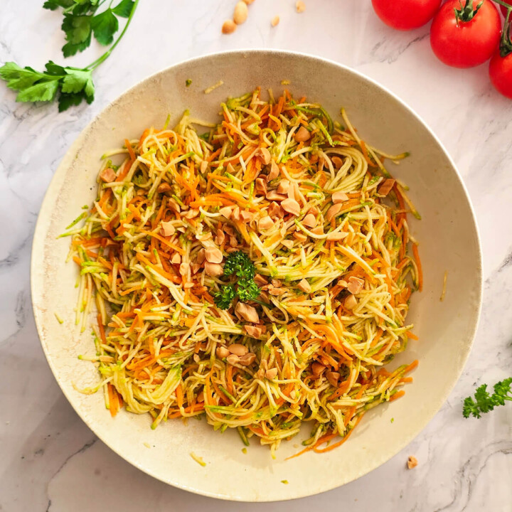 Une salade de Courgettes Carottes Râpées dans une assiette blanche.