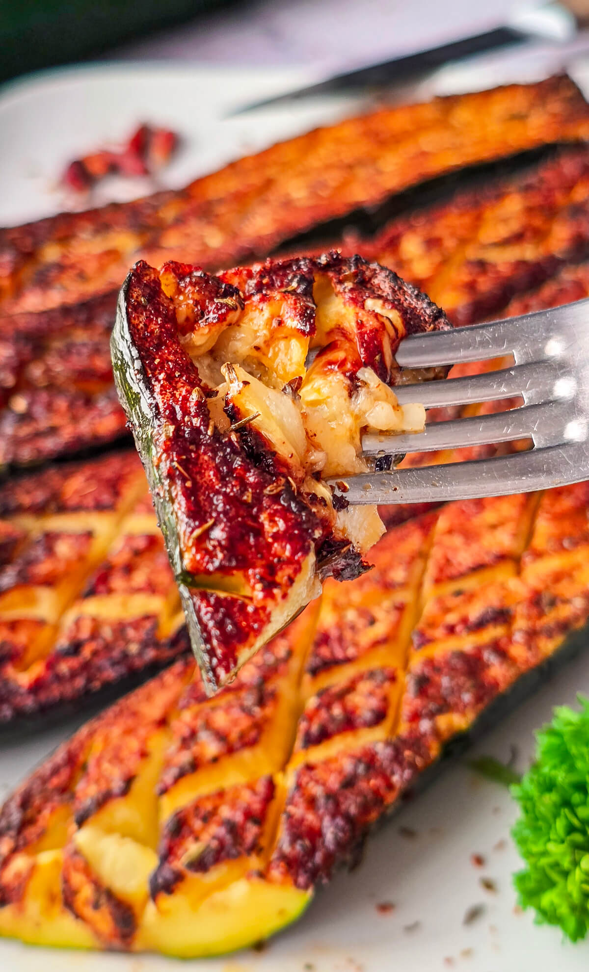 Une fourchette tenant un morceau de courgette grillée.