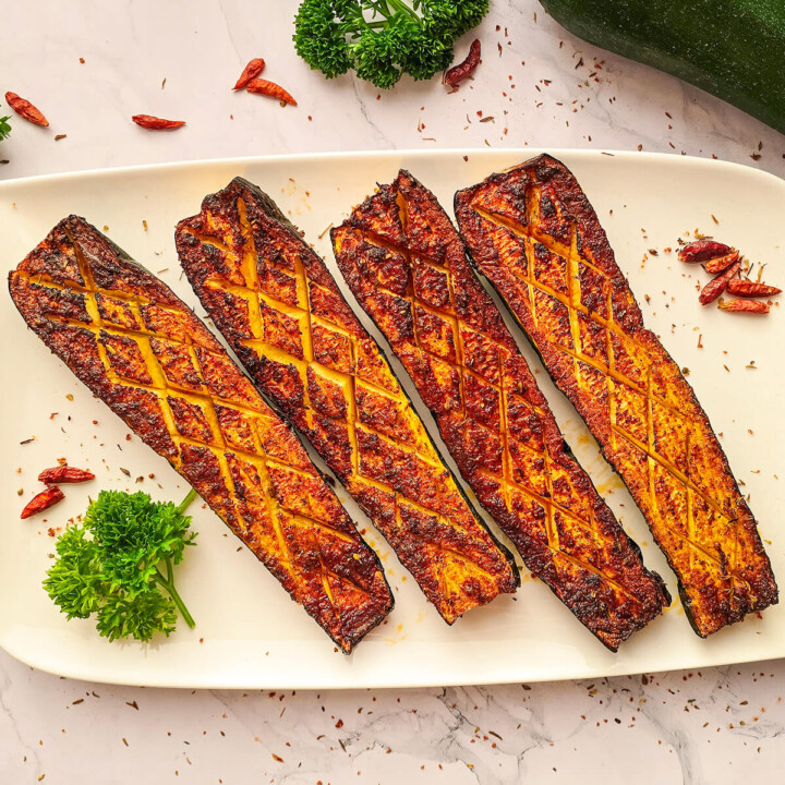 Des courgettes grillées au airfryer dans une assiette blanche.