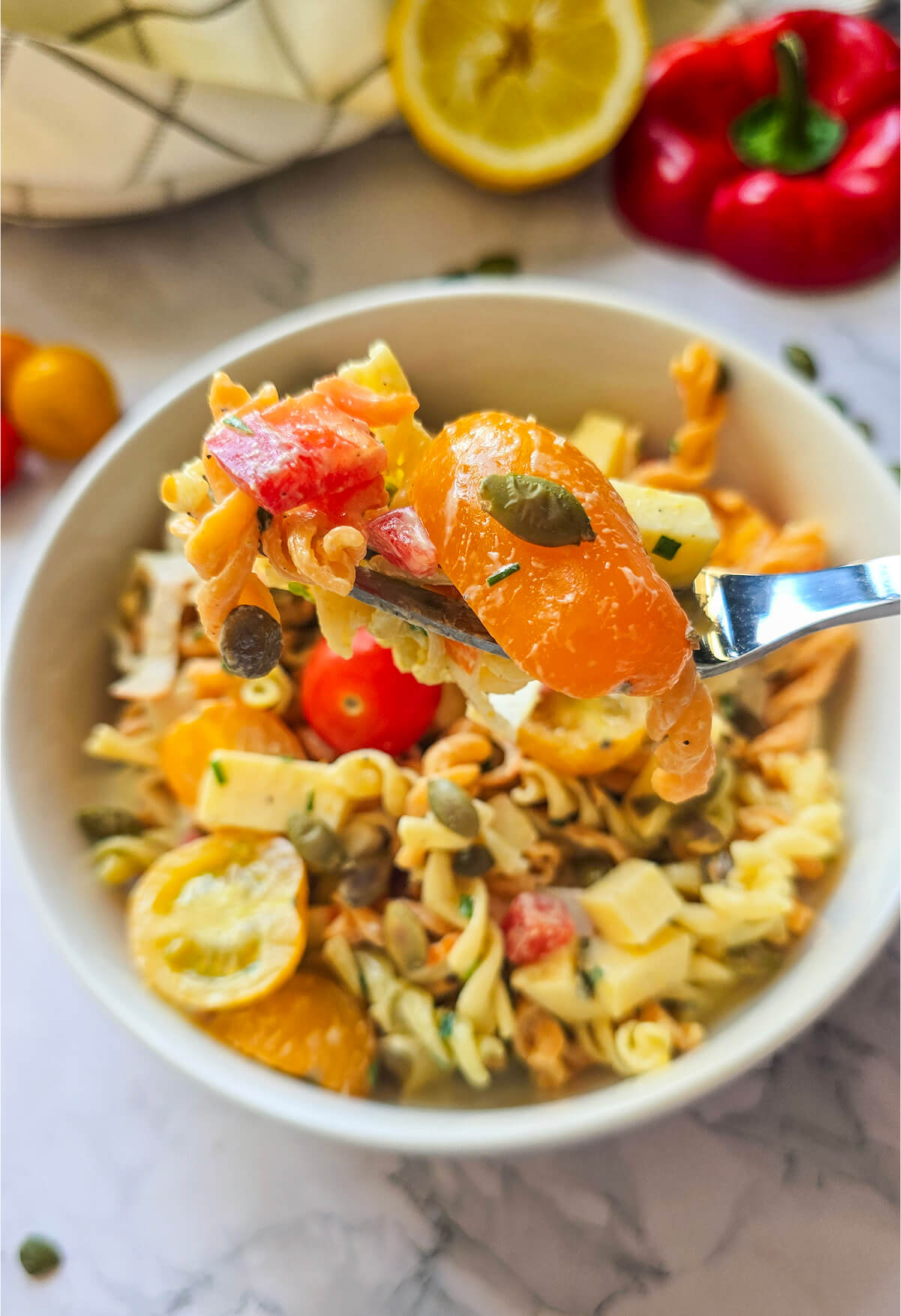 Une salade de Pâtes au Surimi sur un fond blanc marbré..
