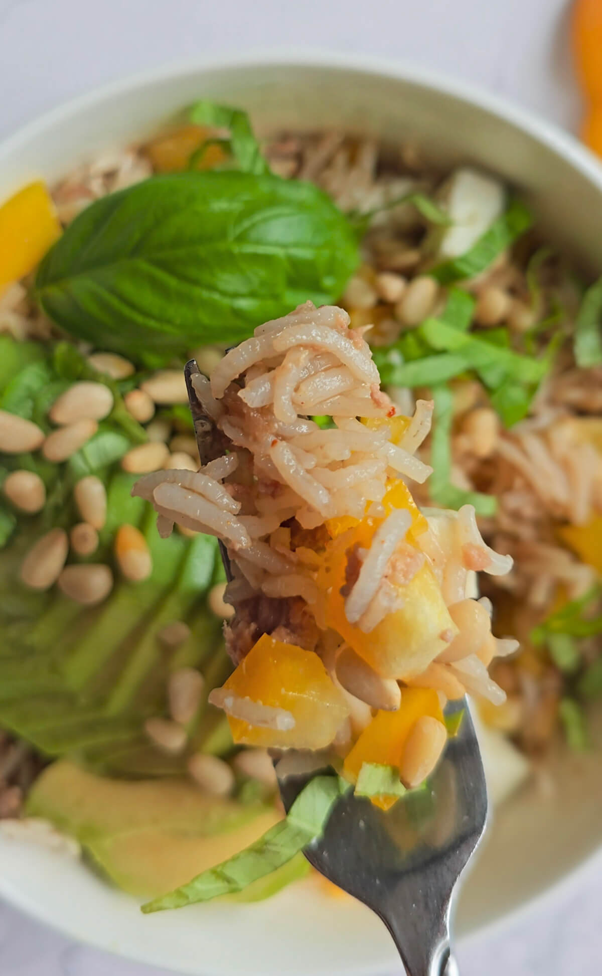 Une fourchette tenant un morceau de salade de thon.