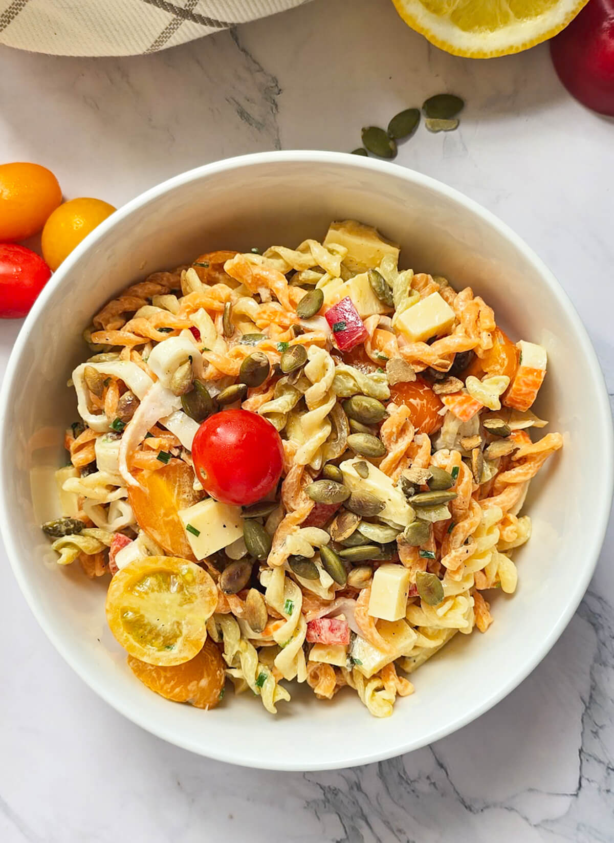 Une salade de pâtes au surimi dans un bol blanc.