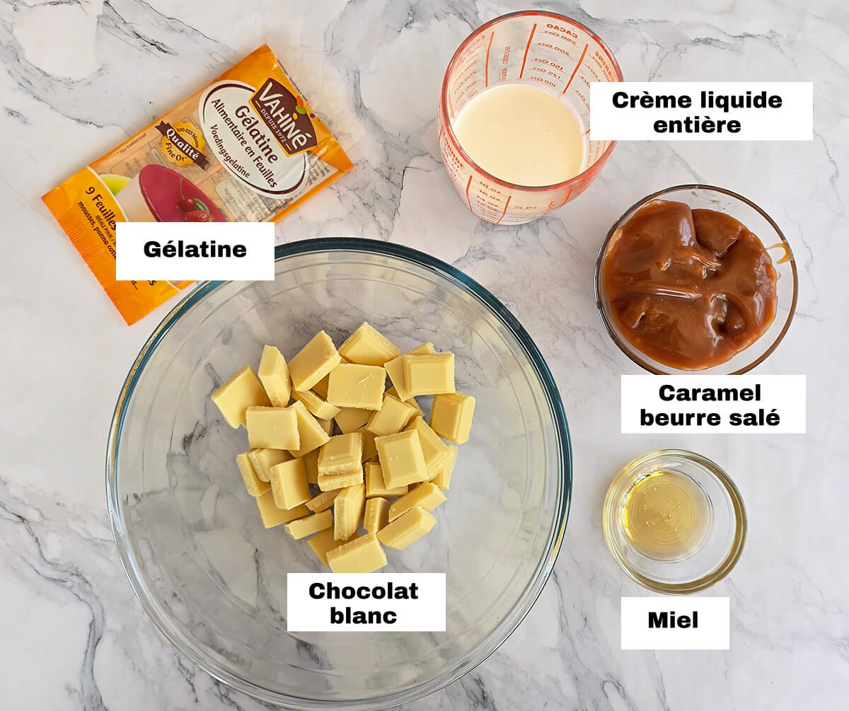 Des ingrédients pour une recette de ganache caramel beurre salé, sur un fond blanc marbré.