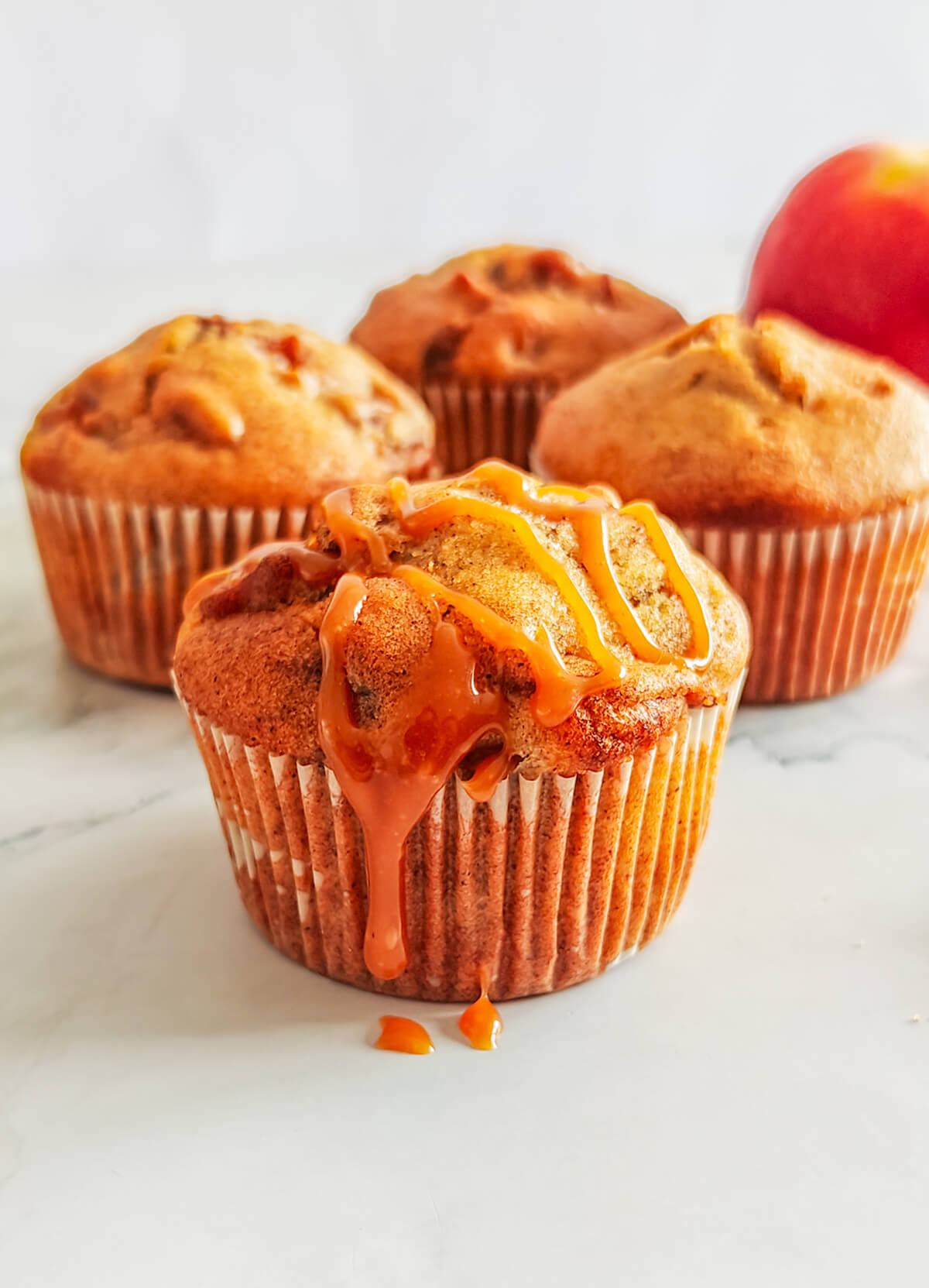 Des muffins pommes cannelle sur un fond blanc.