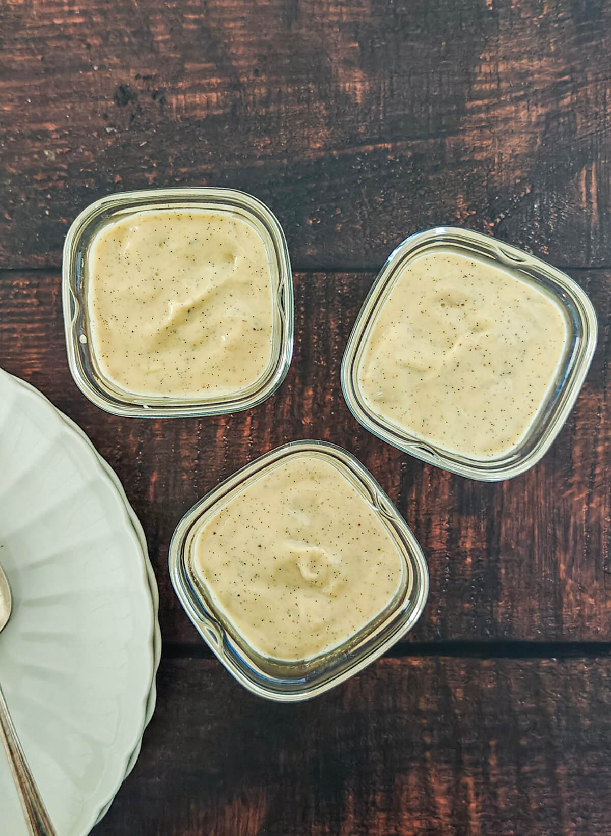 des crèmes dessert à la vanille sur un fond en bois.
