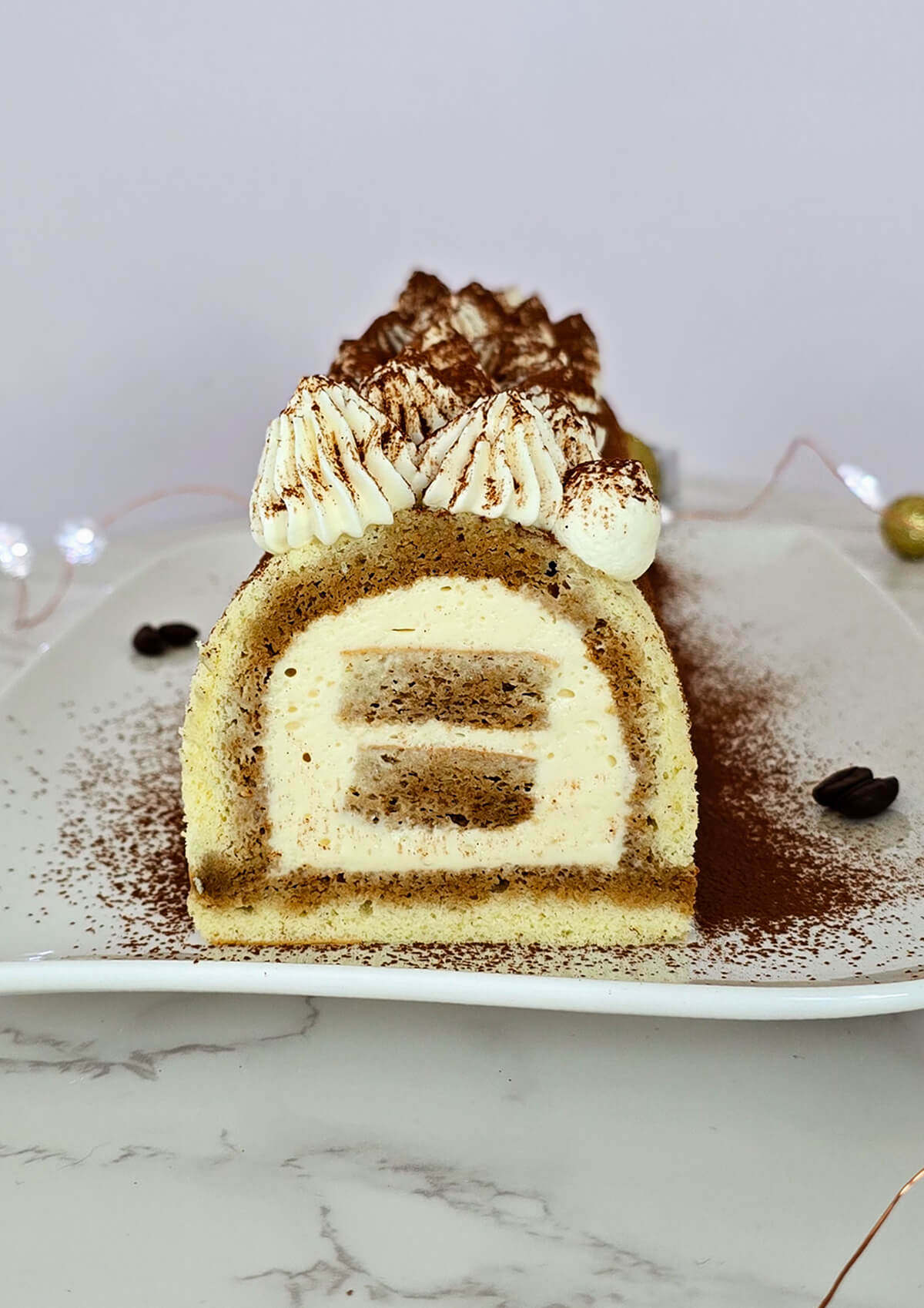 Une bûche tiramisu avec son biscuit cuillère imbibé de café et crème mascarpone.