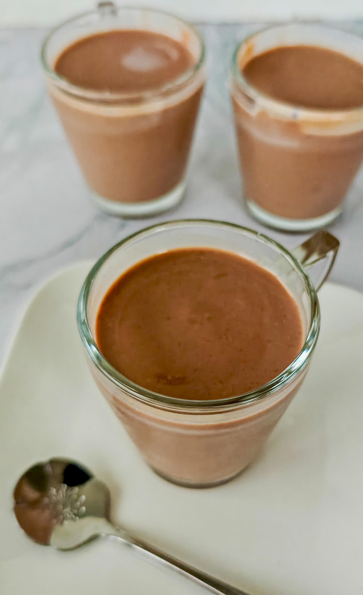 Des crèmes dessert chocolat sur une coupelle blanche.