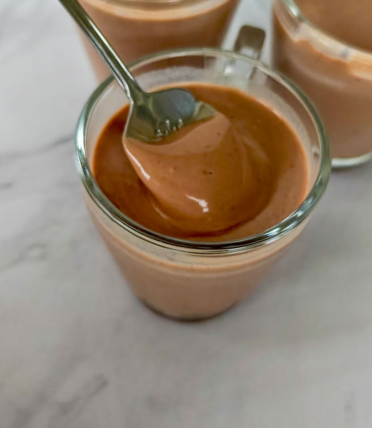 Une crème dessert au chocolat fait maison, cuillère dans la verrine.