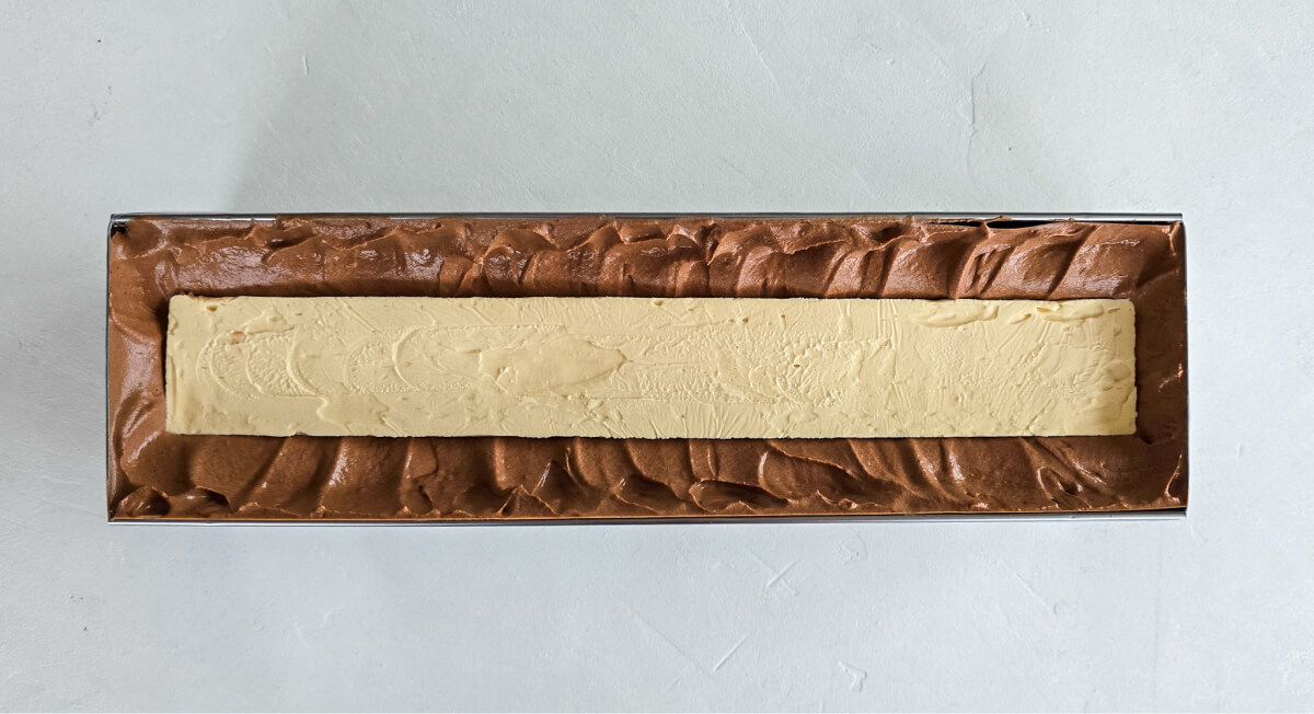 Chocolate mousse and the caramel ganache insert placed inside the pear caramel yule log mold.