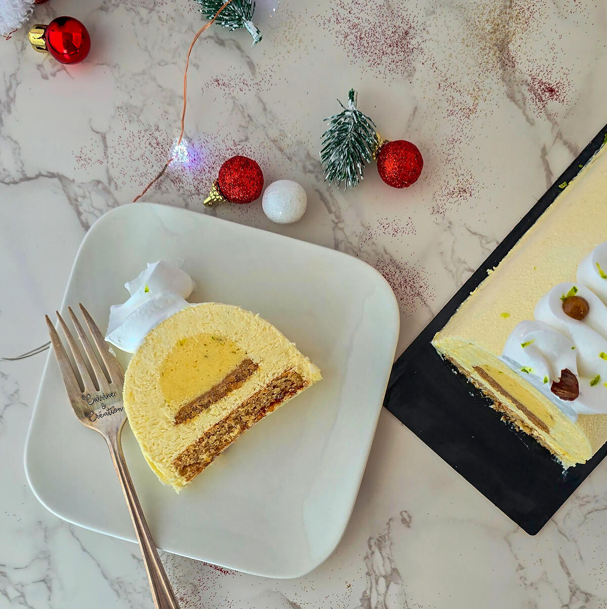 Une part de bûche au citron et noisette dans une petite assiette.