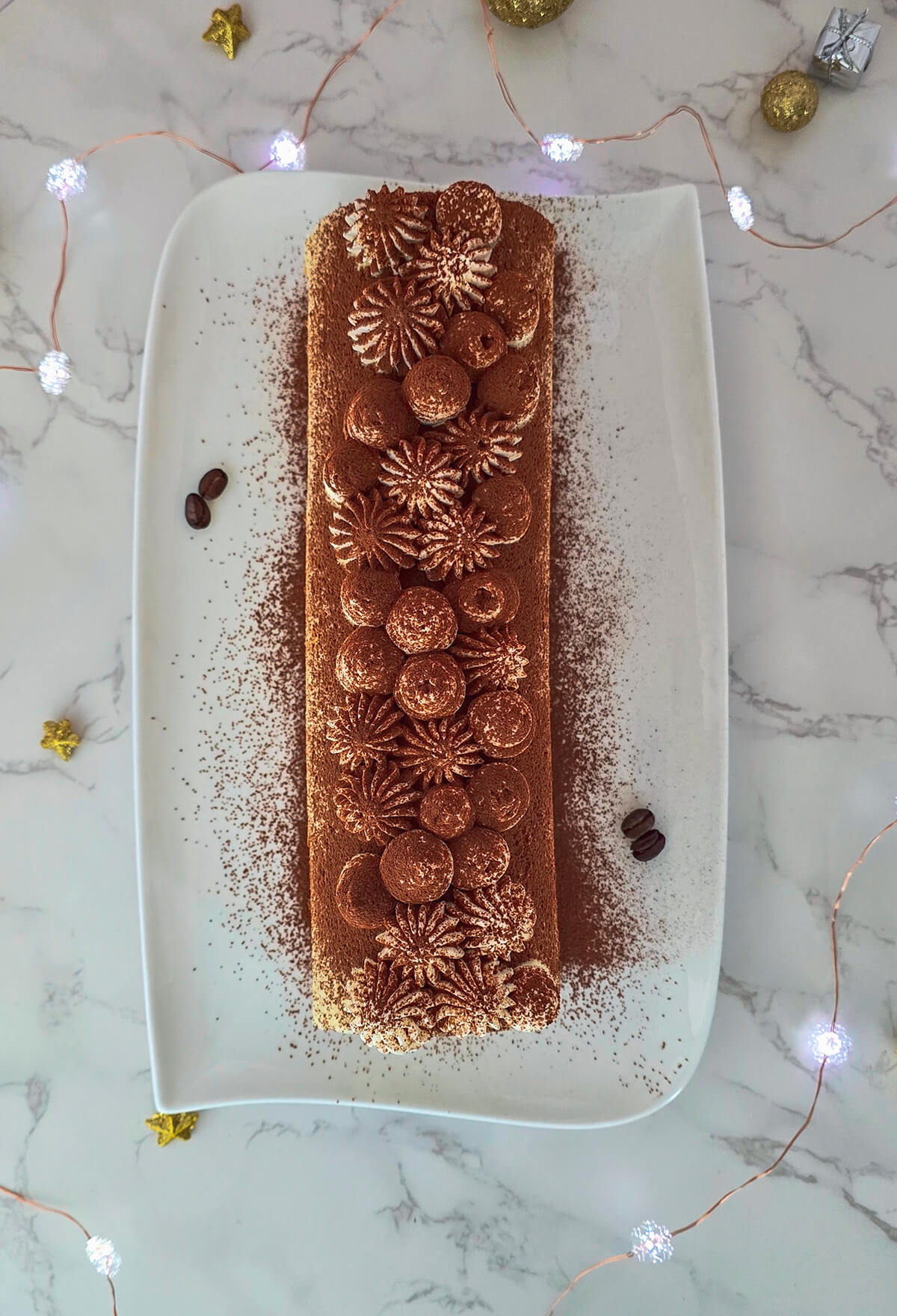 Une buche tiramisu rapide et facile dans un plat blanc.