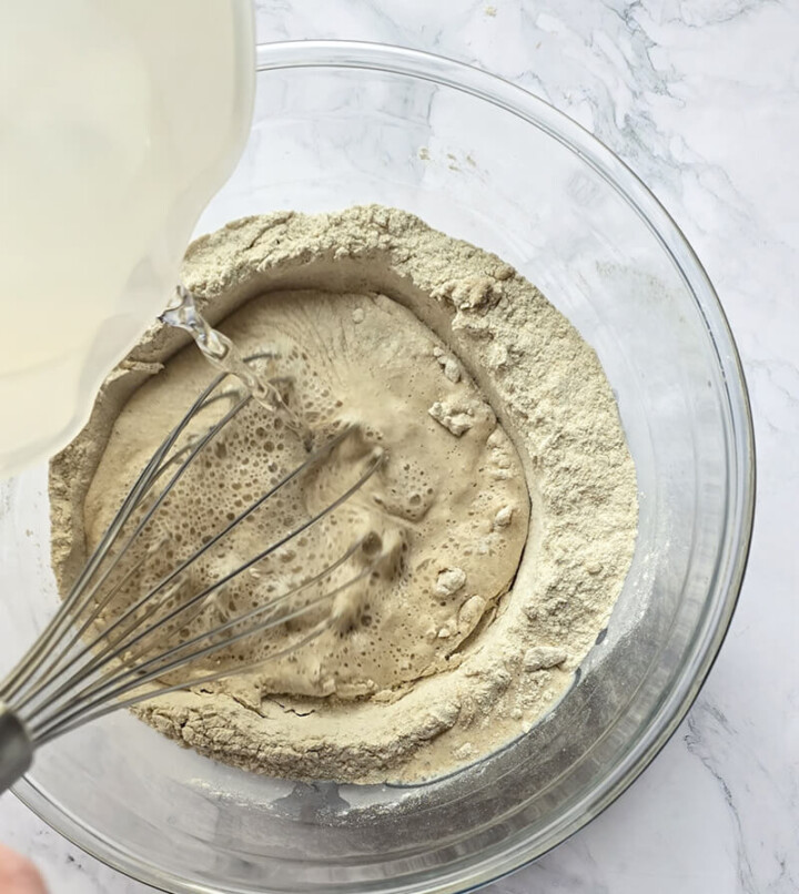 Ajout de l'eau dans la pâte à crêpes au sarrasin.