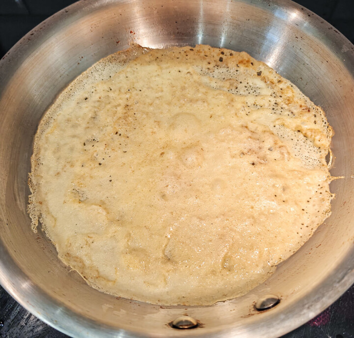 La cuisson d'une crêpe dans une poêle en inox.