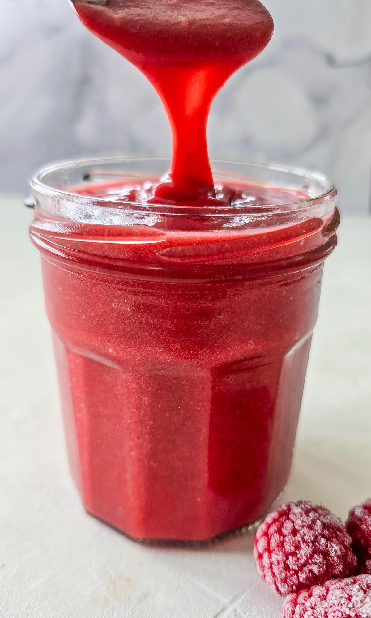 Une recette de curd à la framboise dans un pot de confiture.