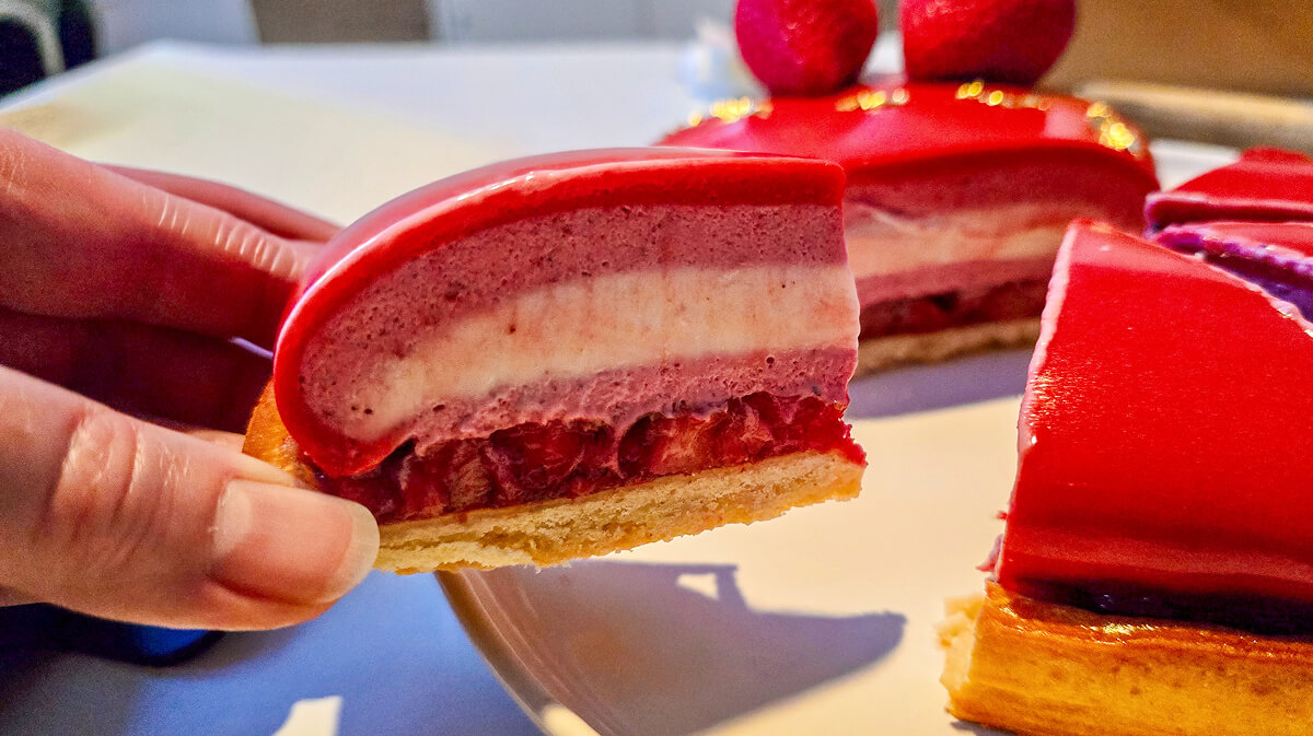 Une part d'entremets fraise sur une table.