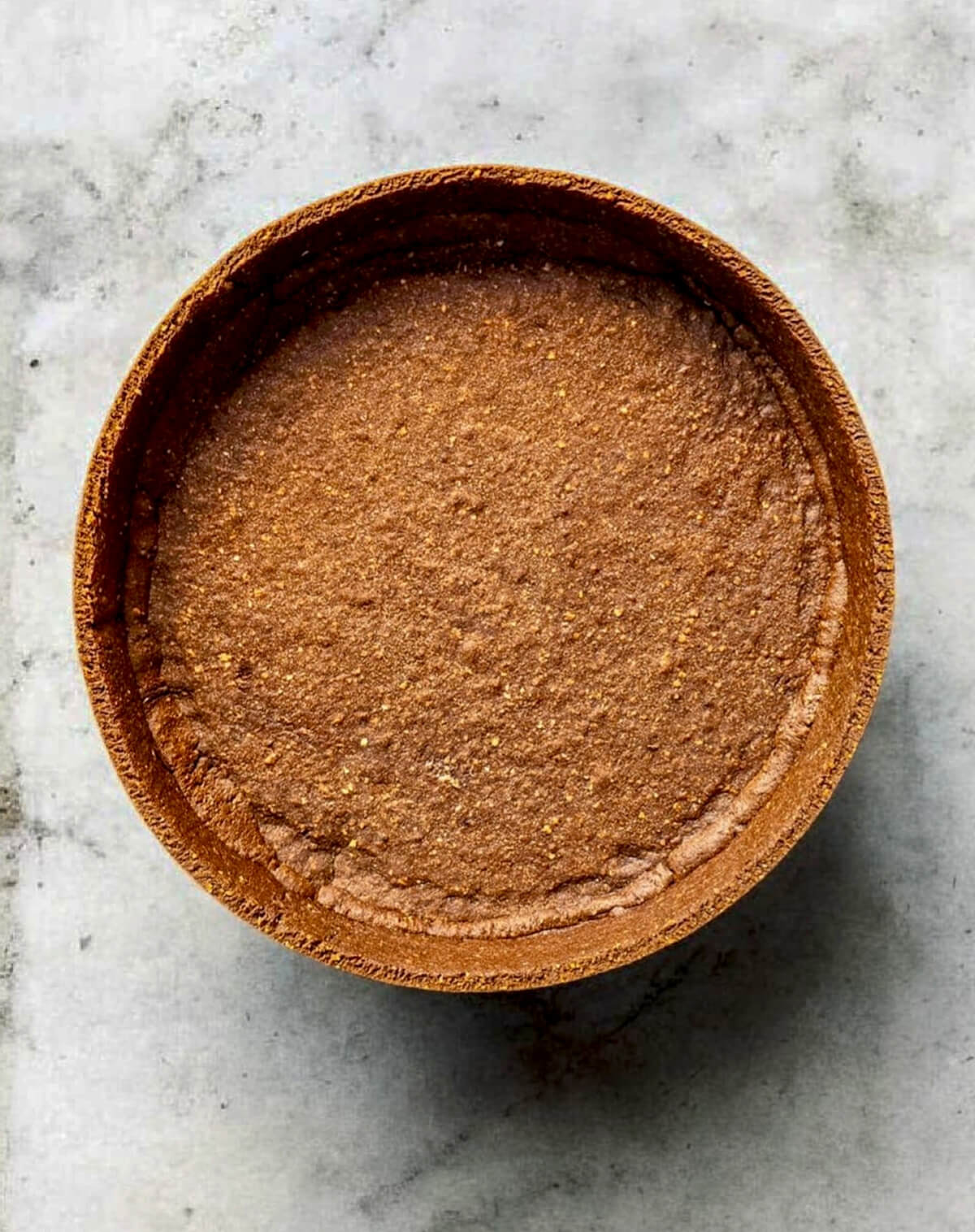 Une pâte sucrée chocolat sur un fond blanc marbré.