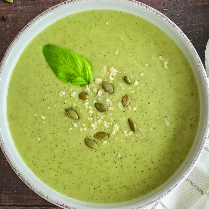 Un bol de velouté pommes de terre courgettes sur un fond boisé.