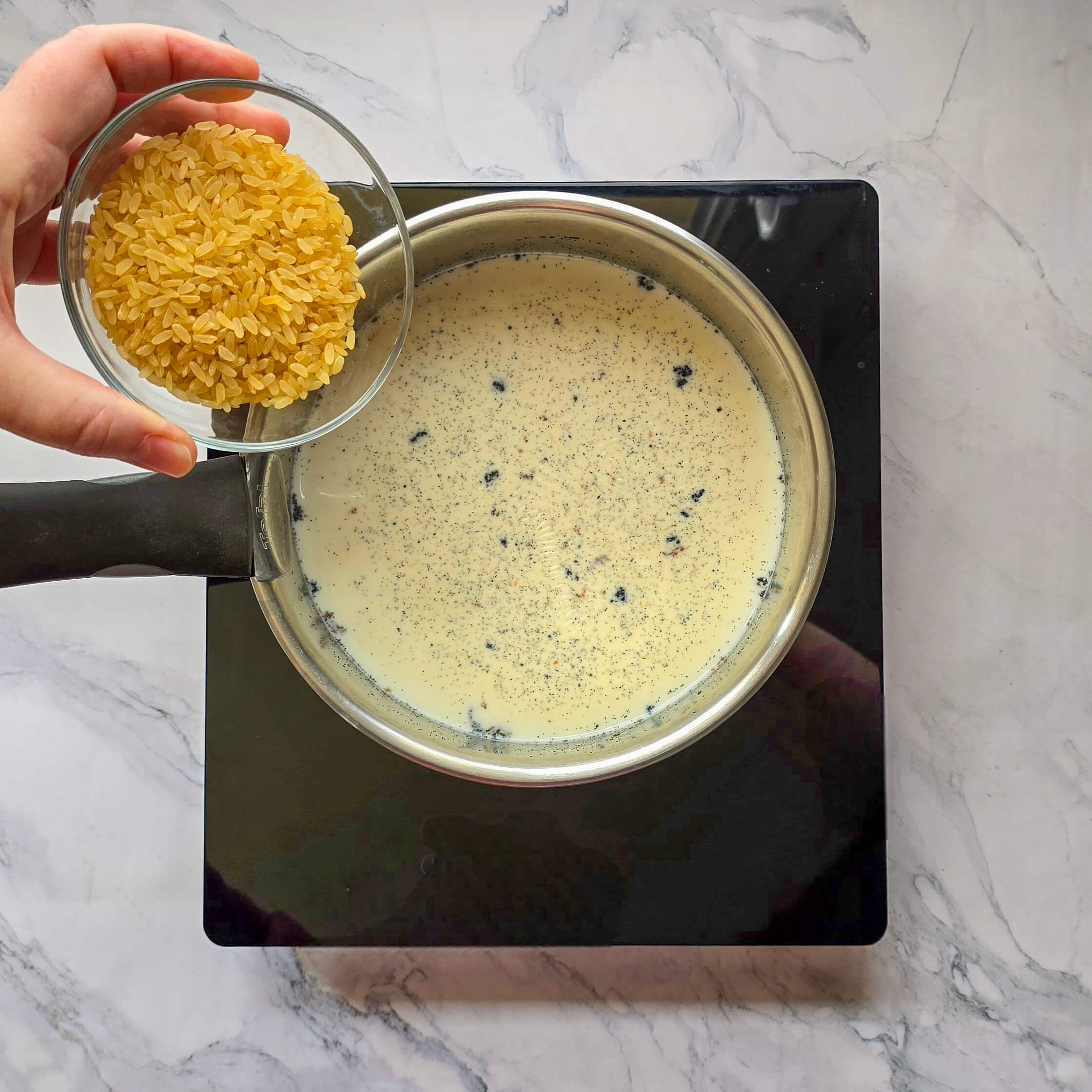 Verser le riz rond (spécial dessert) dans le lait chaud vanillé pour la cuisson.