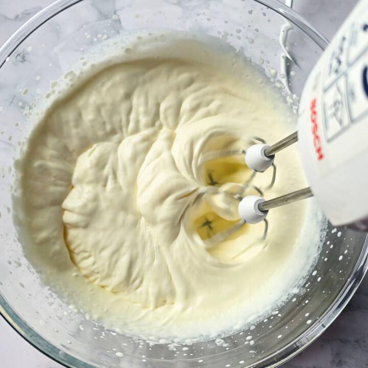 Un batteur électrique qui bat la crème en chantilly dans un saladier.