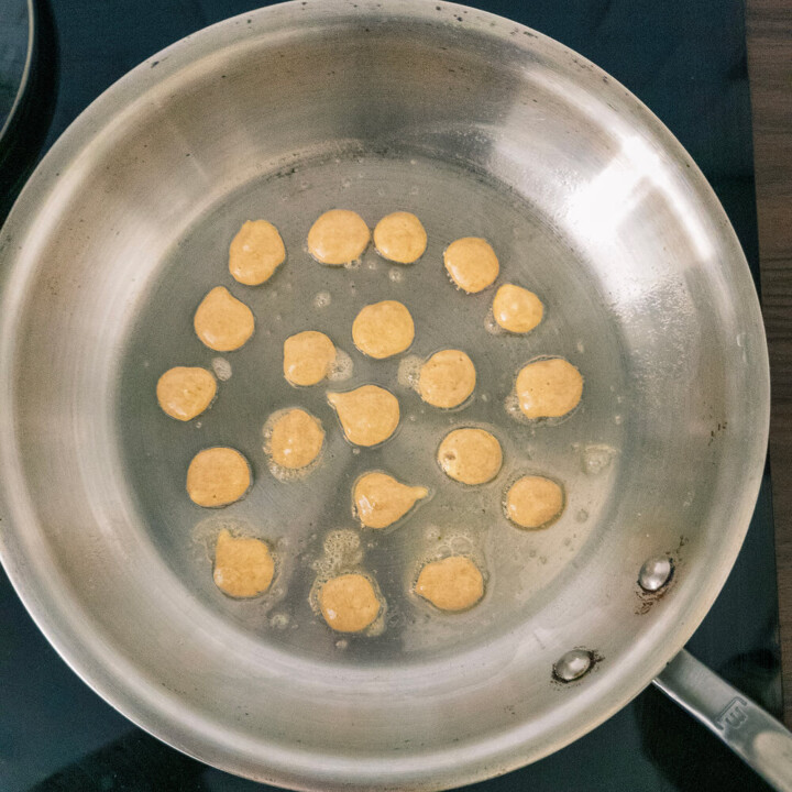 La cuisson des mini-pancakes banane dans une poêle en inox.