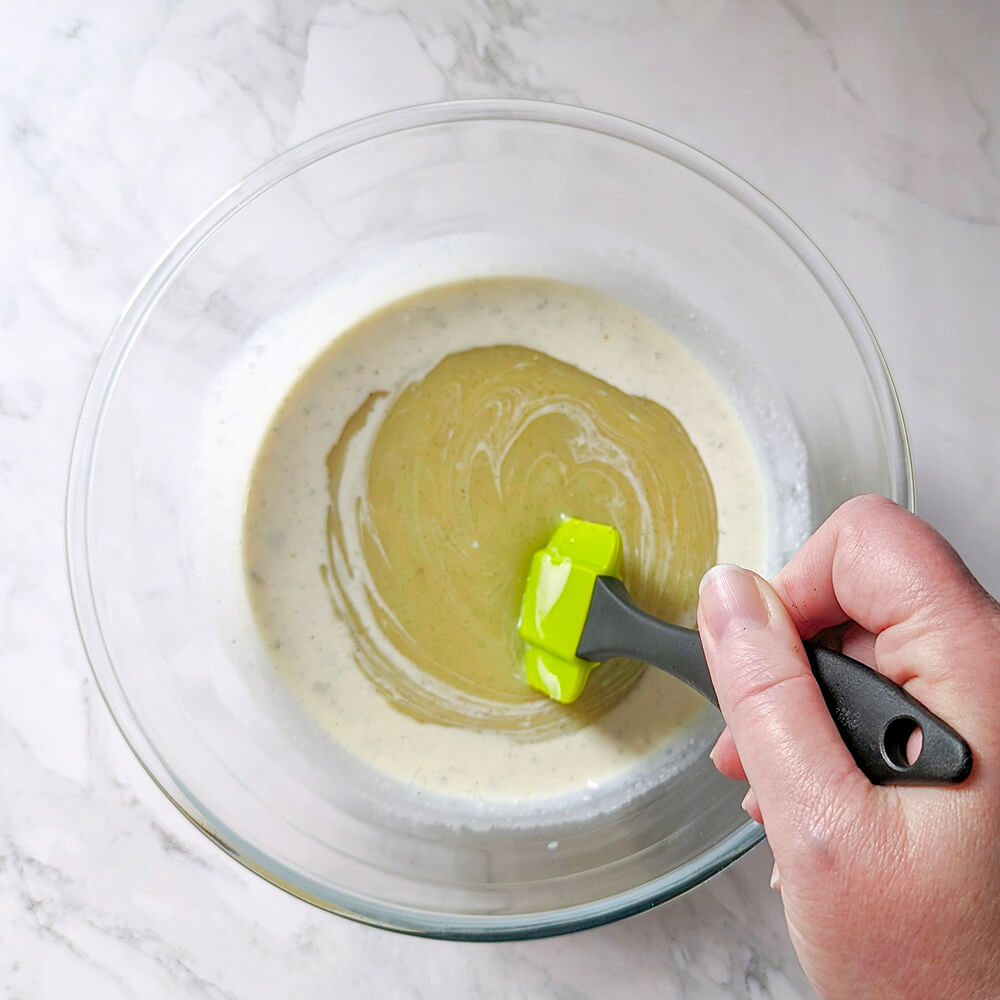 Mélange à la maryse au centre du bol pour débuter l'émulsion entre le chocolat blanc fondu et la crème chaude à la vanille.
