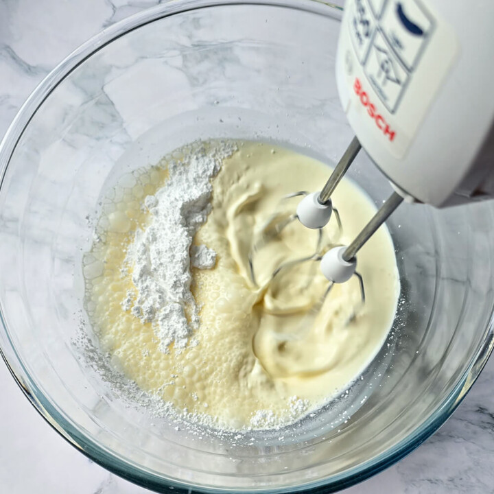 Un batteur et un saladier contenant de la crème pour faire de la crème chantilly maison.
