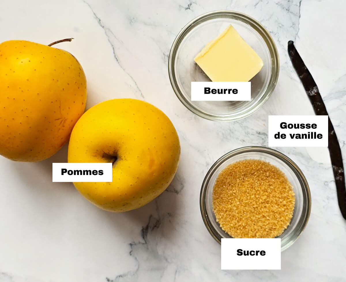 Des ingrédients pour préparer une compote de ponnes vanille, sur un fond marbré.