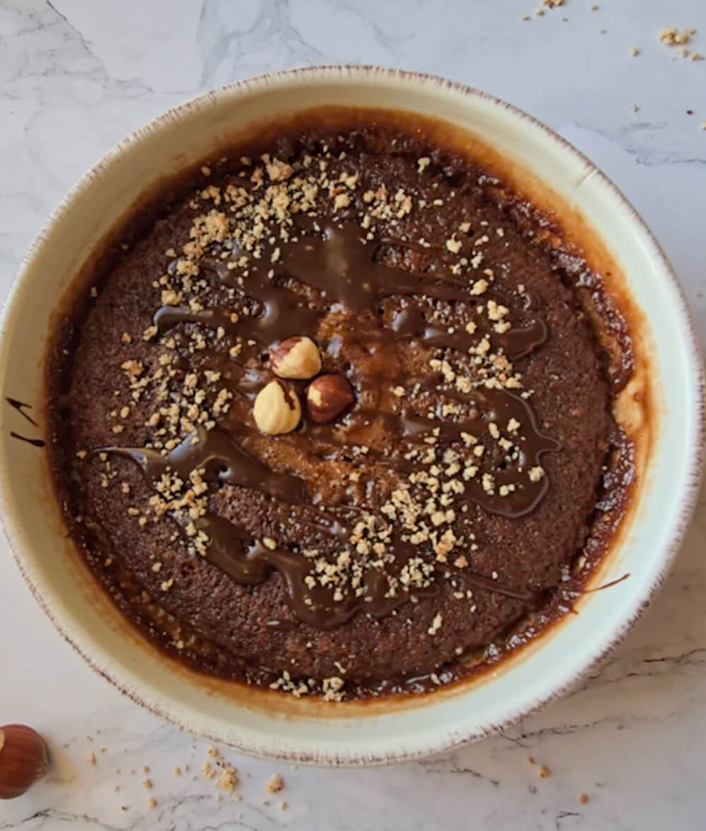 Un bowlcake après cuisson parsemé de noisettes concassées.