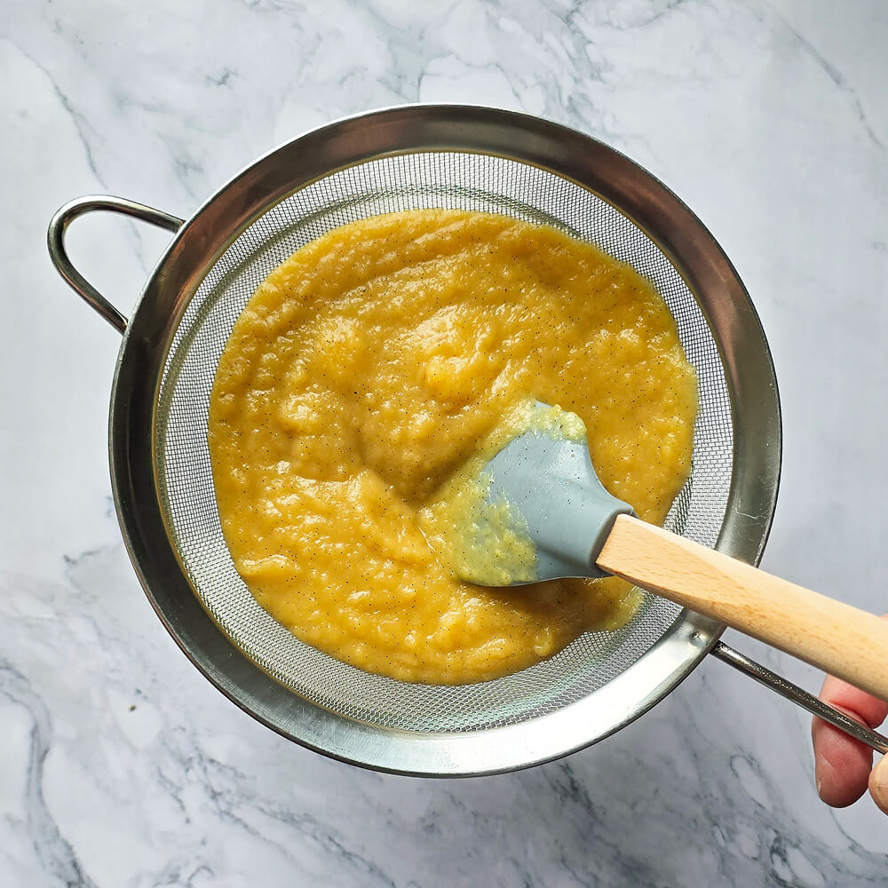 Passer au tamis une compote avec une maryse, sur un fond marbré.