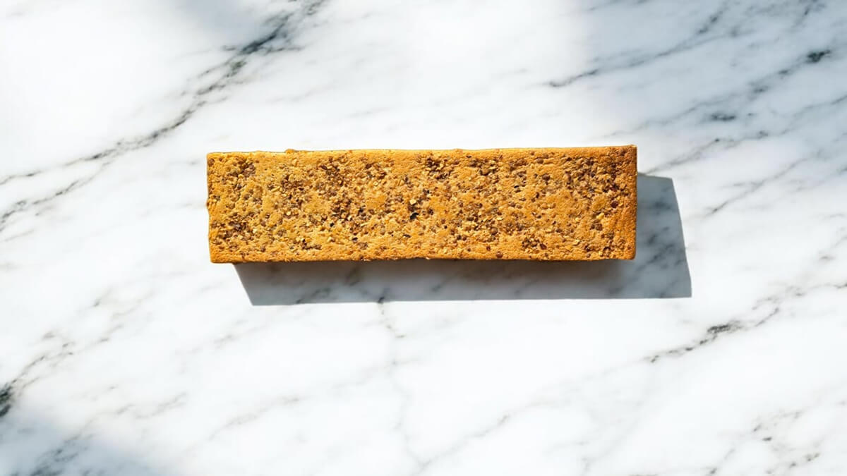 Un biscuit joconde noisette sur un fond marbré blanc.