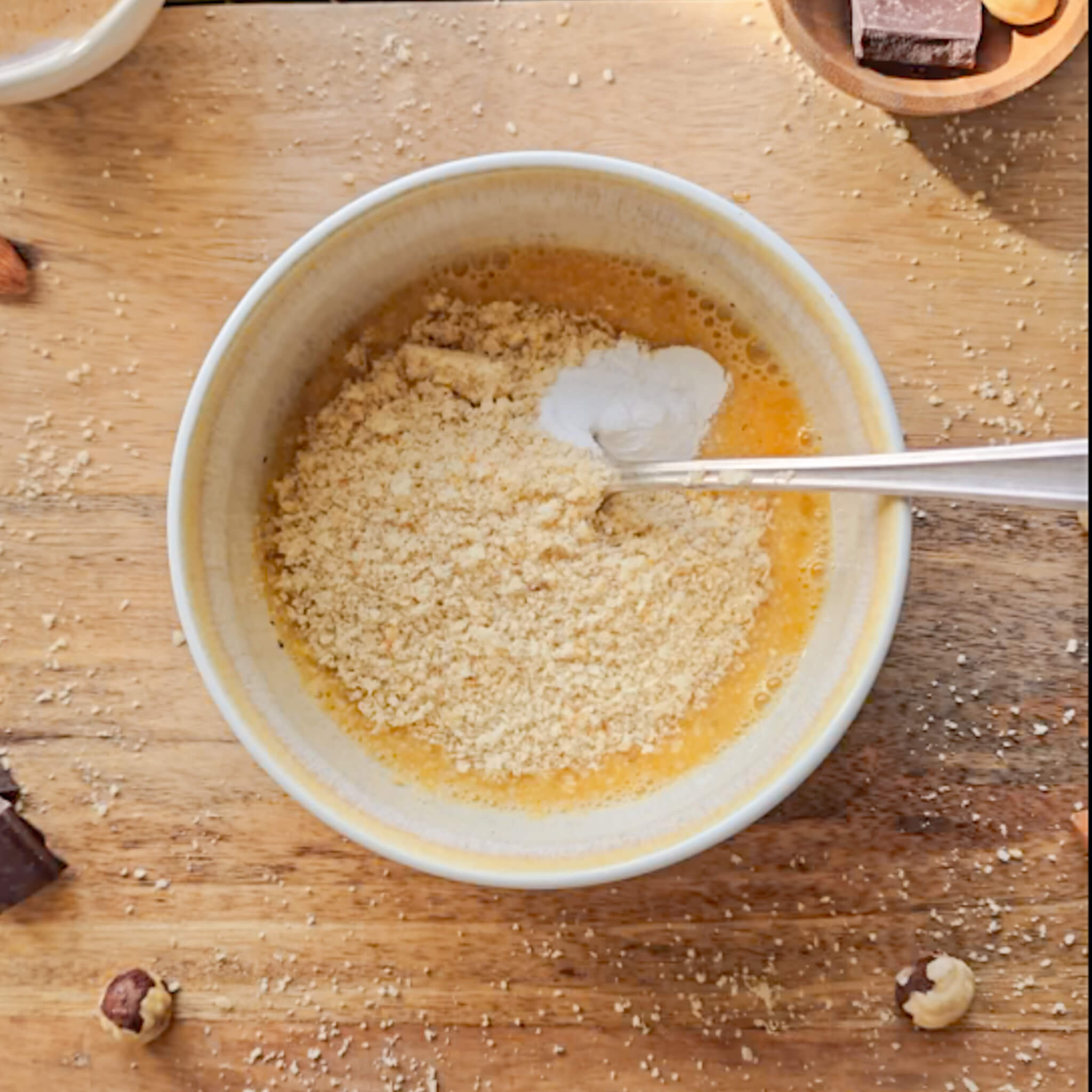 De la farine et de la levure sont ajoutées à la pâte liquide dans le bol.